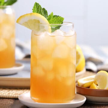 Glasses of Arnold Palmer drink garnished with lemon and mint.