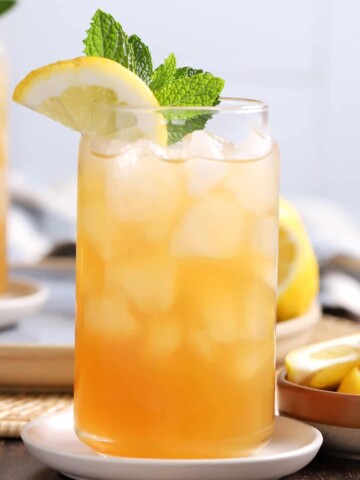 Glasses of Arnold Palmer drink garnished with lemon and mint.
