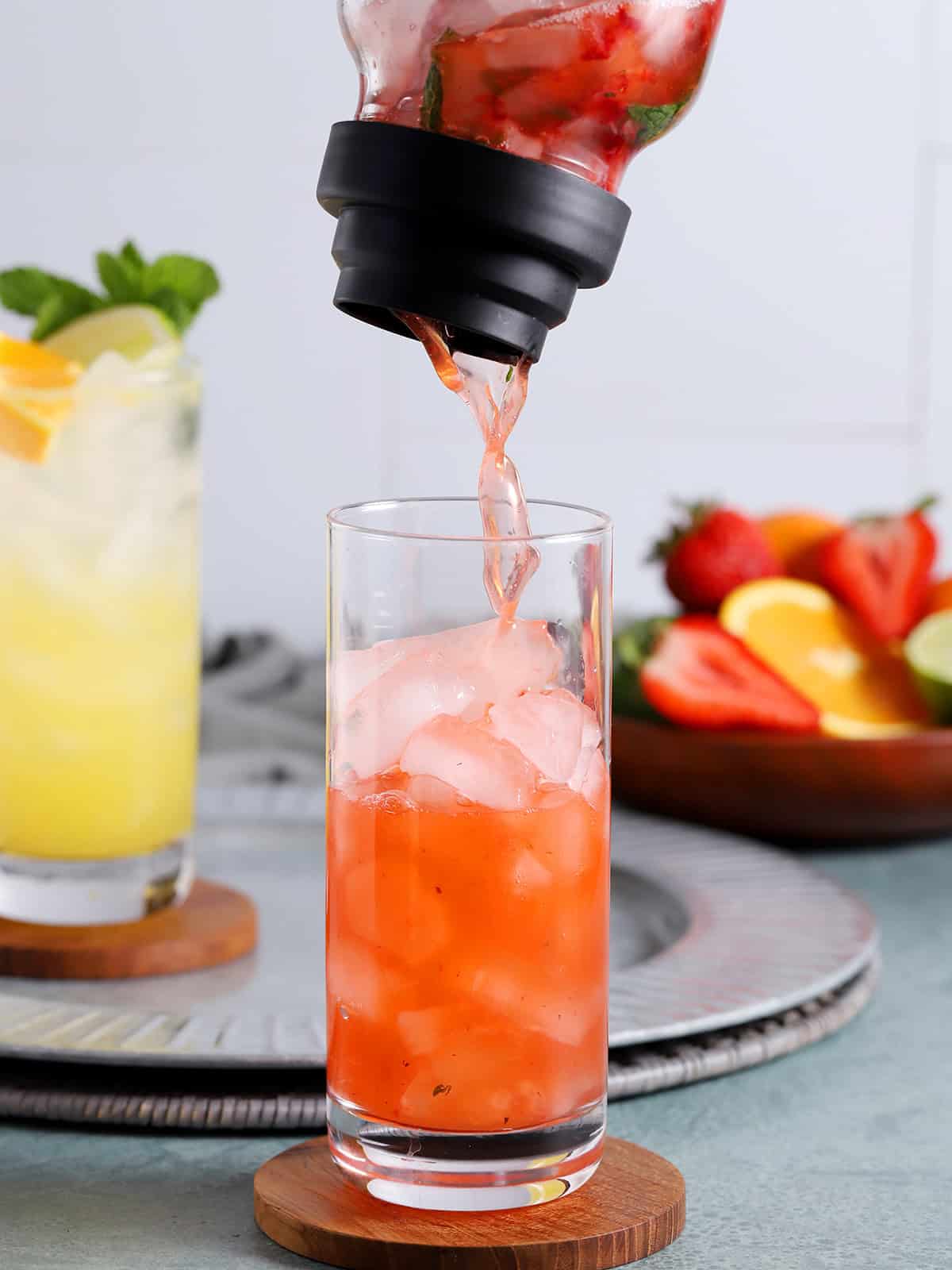 Tequila Smash cocktail being poured from a shaker into a tall glass.