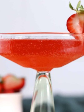 A glass of Strawberry Bourbon Cocktail garnished with fresh strawberries.
