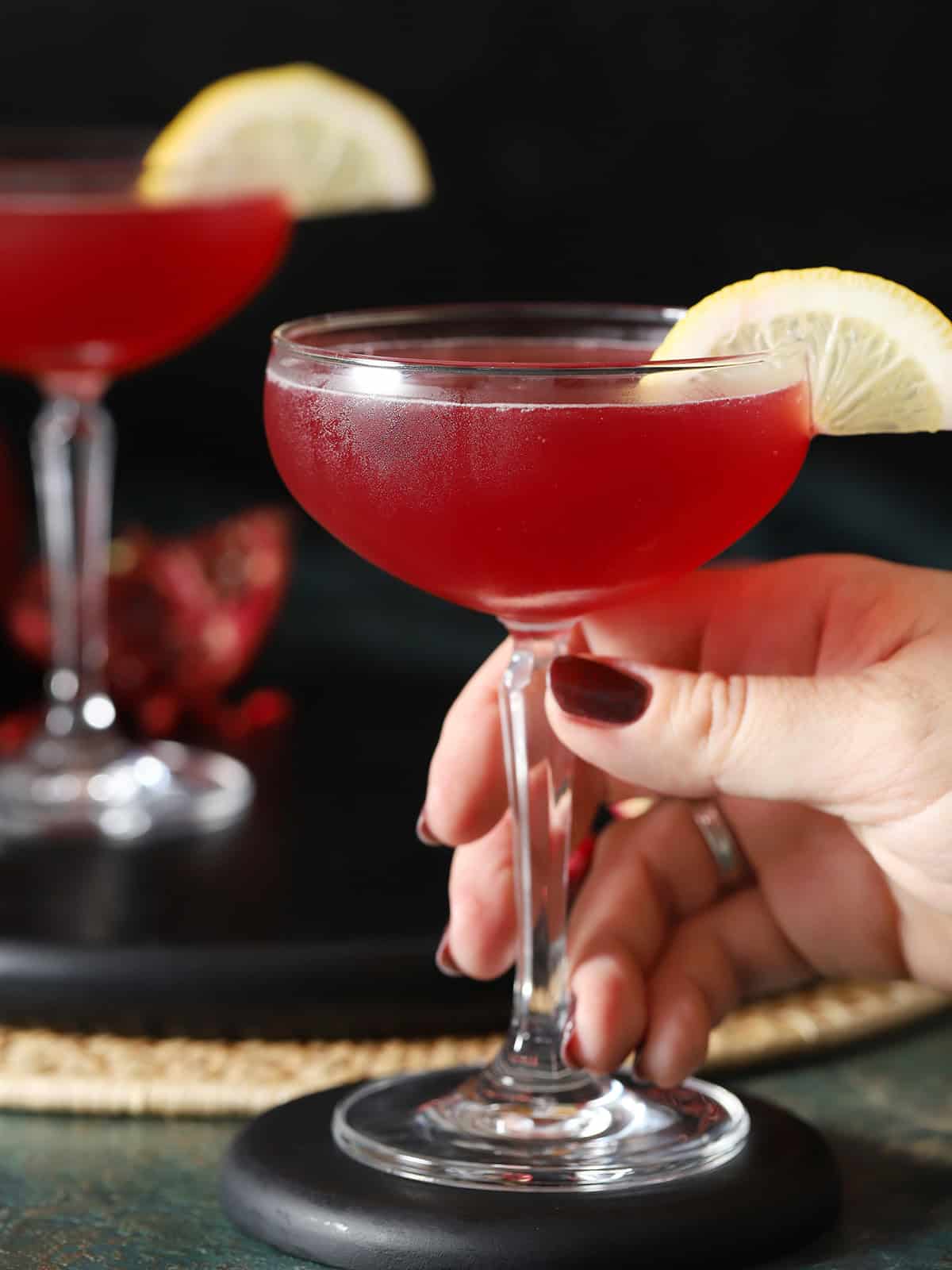 A hand reaching in to pick up a glass filled with cocktail.