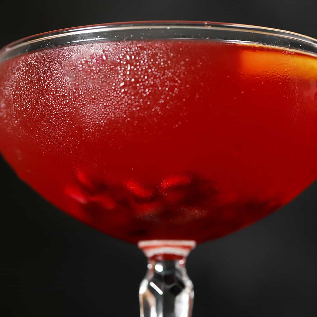 Pomegranate arils at the bottom of a coupe glass.