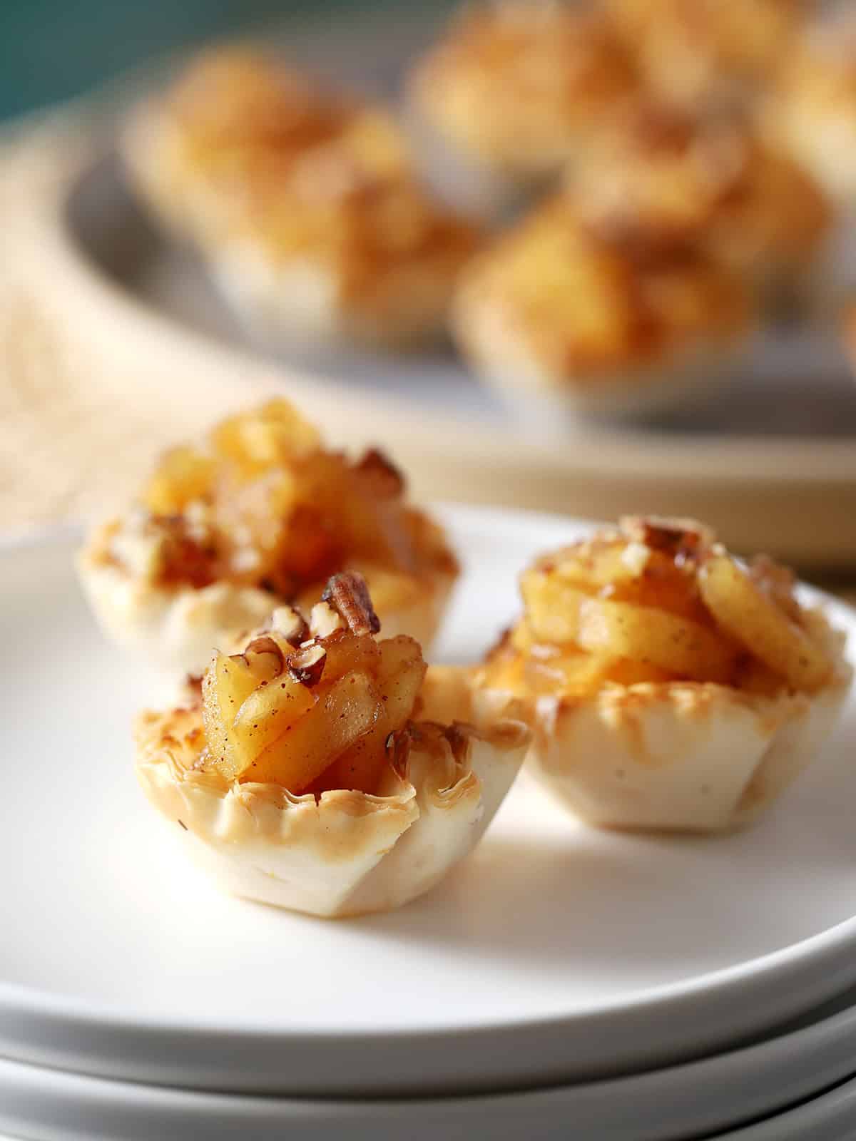 A small plate with three apple pie bites.