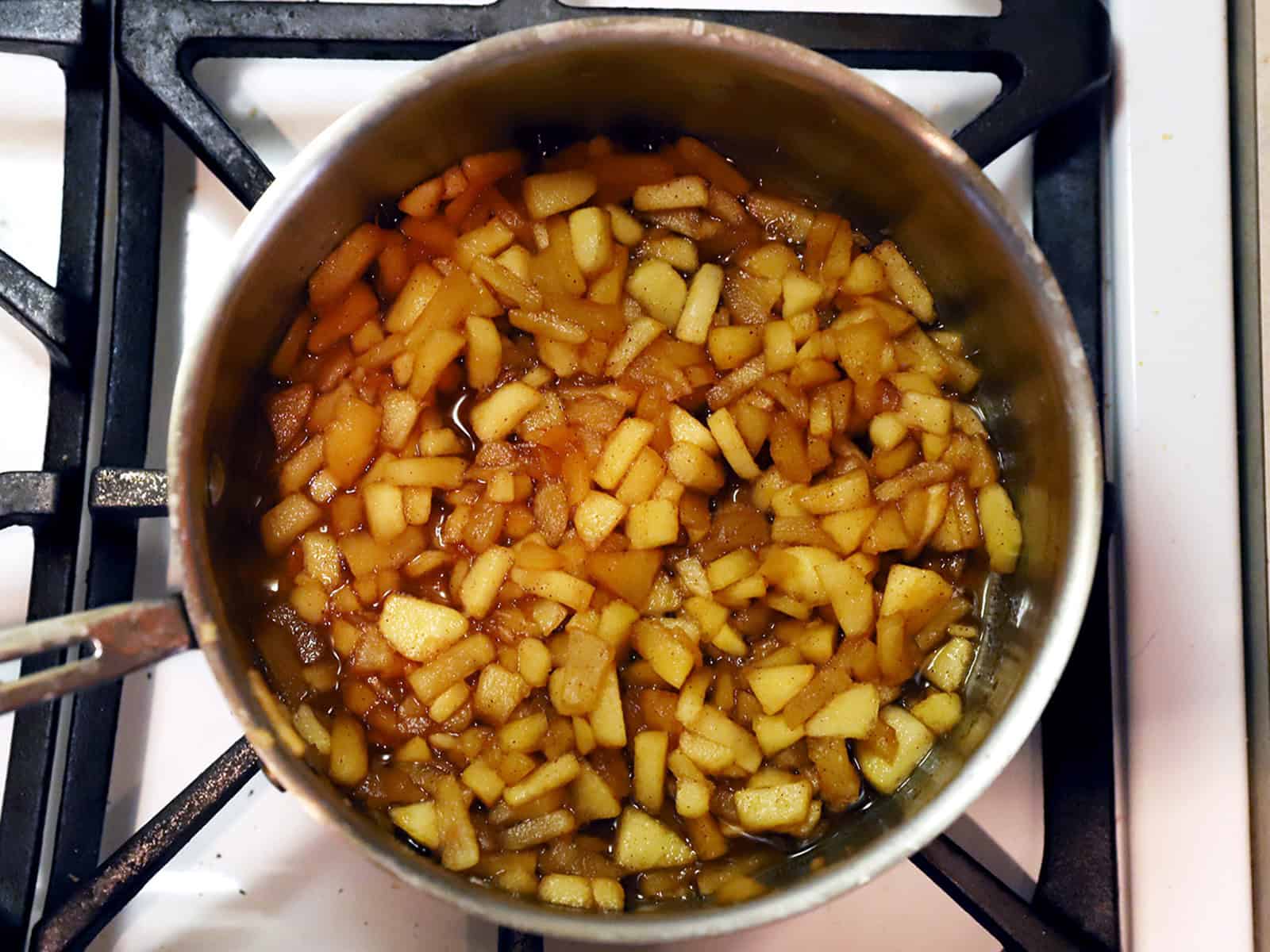 Cooked apple filling in a pot on the stove.