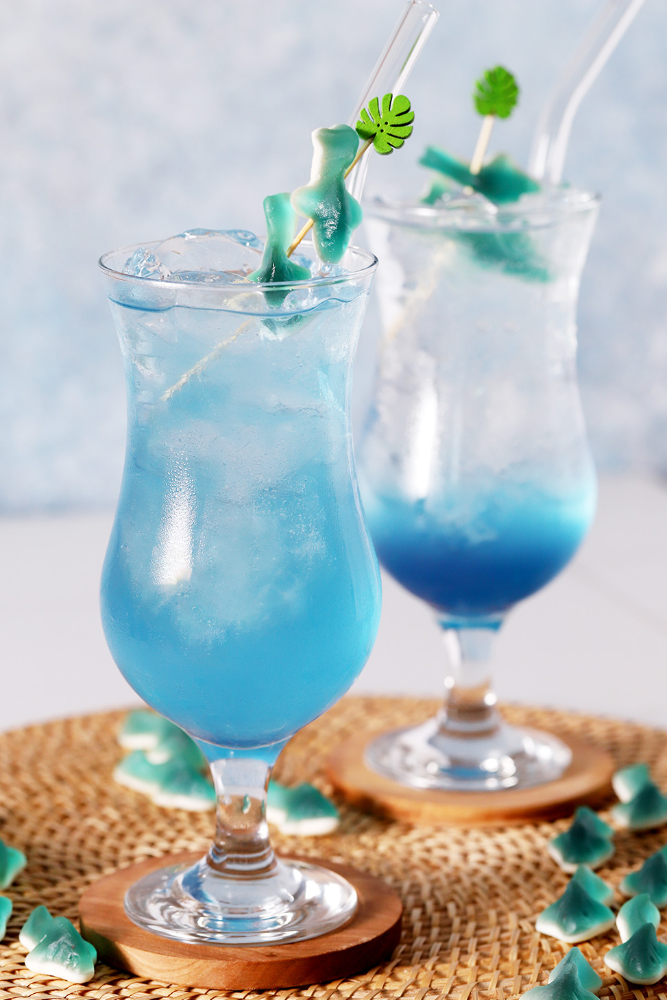 A pair of blue mocktails, one stirred and one layered.