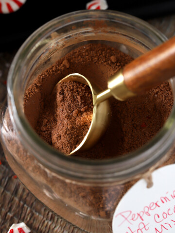 A tablespoon in a mason jar of peppermint hot cocoa mix.