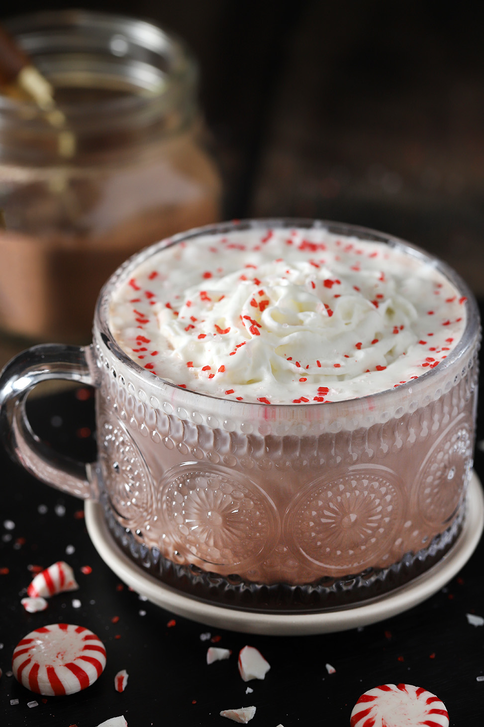 A mug of peppermint hot chocolate with whipped cream on top.