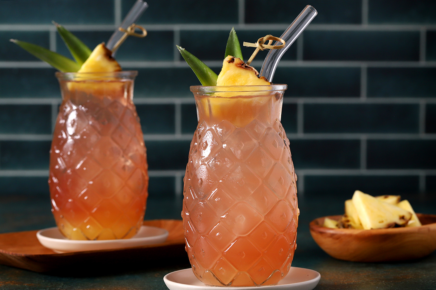 Glasses of Malibu Bay Breeze garnished with wedges of pineapple and pineapple leaves.